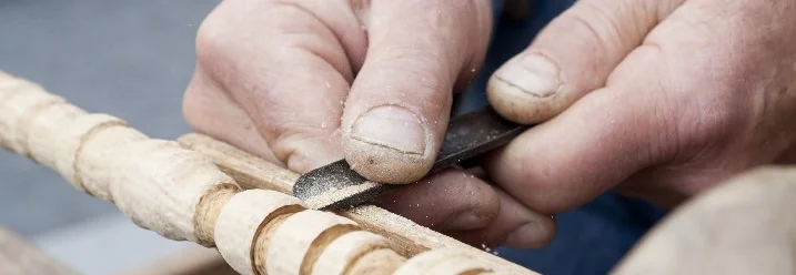 Hände bearbeiten Holz mit Hobeleisen